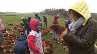 Annette Krause hält ein Huhn auf dem Arm