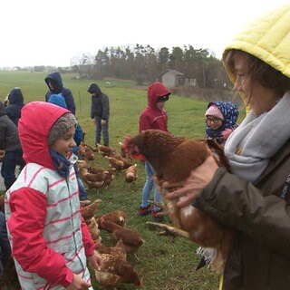 Annette Krause hält ein Huhn auf dem Arm