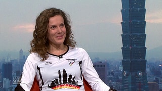 Treppenläuferin Verena Schmitz sitzt im Studio und lächelt. 