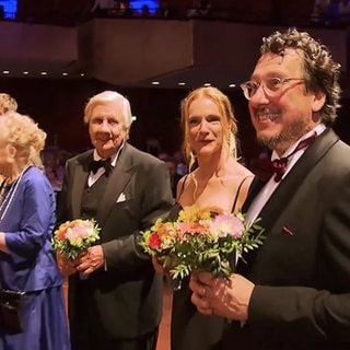 Familie Lamadé mit Blumensträußen auf einem Event