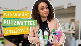 Putzmittel gibt es in Supermärkten zu Hauf. Nachhaltig sind konventionelle Reinigungsmittel aus dem Discounter aber nicht unbedingt. Ökocheckerin Maral Bazargani in der Mitte des Bildes blickt überrascht in die Kamera. Sie hält vier verschiedene Plastikflaschen in den Händen, welche mit bunten Putzmitteln gefüllt sind. 