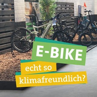 In der Bildmitte sieht man Ökocheckerin Katharina Röben. Sie blickt kritisch in die Kamera und fasst sich fragend an den Kopf. Vor ihr liest man "E-Bike", "echt so klimafreundlich?" hinterlegt mit farbigen Bändern. Im Hintergrund sieht man einen Verkaufsraum in dem verschiedene E-Bikes ausgestellt sind.