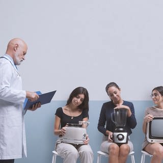 Mehrere Menschen sitzen wie im Wartezimmer beim Arzt nebeneinander und halten unterschiedliche kaputte Haushaltsgeräte auf dem Schoß: Mixer, Toaster, Mikrowelle und Fernseher. Ganz Links im Bild steht ein Arzt. Sollen die Elektrogeräte zur Reparatur oder zum Recycling?