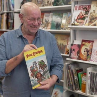 Volker Riedel, Inhaber X-tra-BooX in Frankfurt, mit persönlichem Kindheitslieblingscomic Prinz Eisenherz