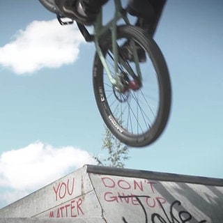 Mountainbike-Fahrer in der Luft während des Sprungs von der Rampe