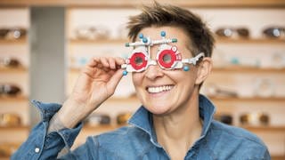 Frau beim Optiker mit Messbrille: Bei Kurzsichtigkeit hat man im Alter den Vorteil, dass man Dinge in der Nähe sehen kann. Aber es gleicht sich nicht mit der Alterssichtigkeit aus. 