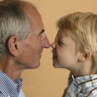 Ein alter Mann und ein Junge stupsen sich mit der Nase an: Alte Menschen riechen anders als junge, denn im Alter verändert sich die Haut. Die Fette, die wir über die Talgdrüsen ausscheiden, verändern sich. Die Haut verliert an Feuchtigkeit und ist daher im Alter trockener. Damit ändert sich auch die Zusammensetzung der Düfte, die unser Körper und unsere Duftzellen abgeben.