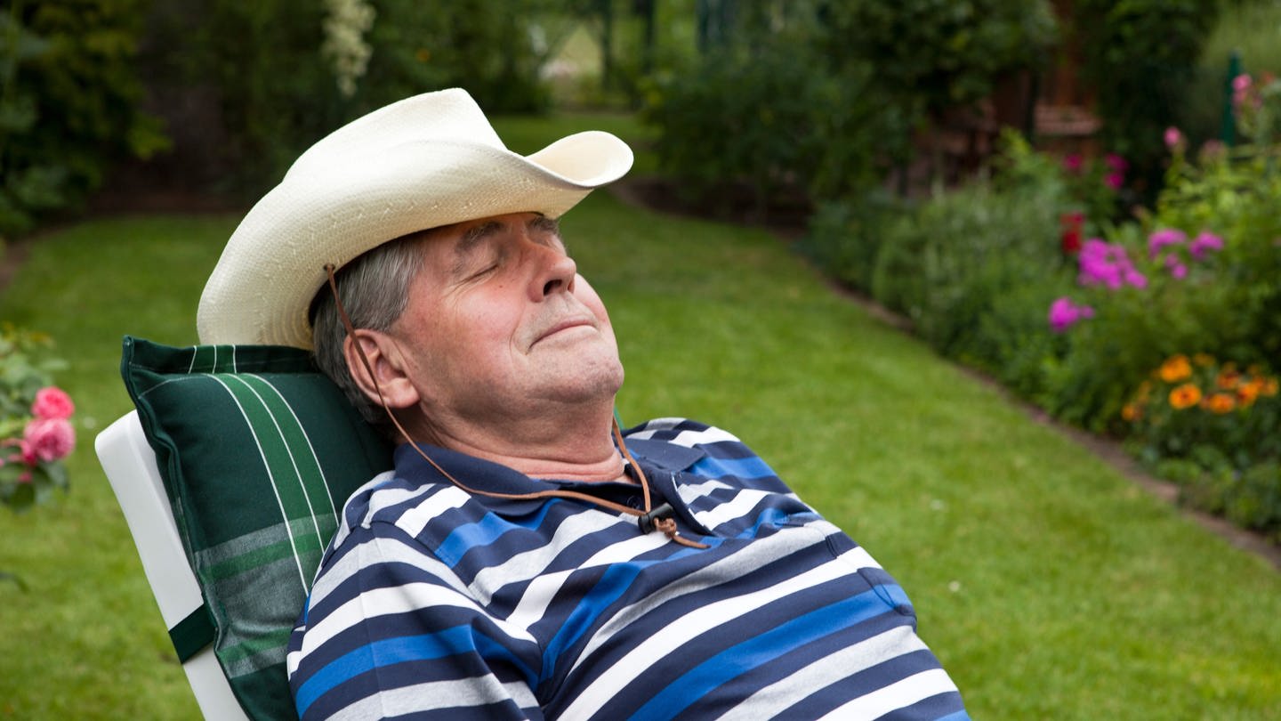 Powernapping: Mann mit Hut beim Mittagsschlaf im Garten