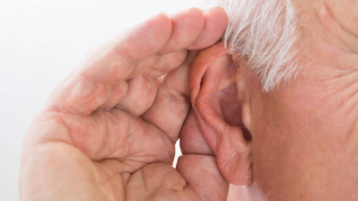 Älterer Mann hält sich die Hand hinters Ohr, um besser zu hören: Das Gehör von Dementen zu testen ist nicht ganz einfach. Es gibt heute jedoch Verfahren, die man bei betagten und dementen Personen verwenden kann – objektive Tests, bei denen man keine weitere Mitarbeit der Patientinnen und Patienten braucht.