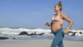 Schwangere treibt Sport am Strand