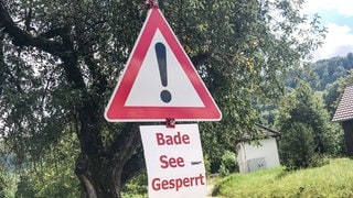 Warnschild mit der Aufschrift "Badesee gesperrt": Umgekippte Badeseen sind nicht nur für die Umwelt eine Katastrophe, sie bergen auch für uns Menschen gesundheitliche Risiken. 