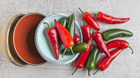 Rote und grüne Chilischoten: Scharf wird die Chili durch bestimmte chemische Stoffe – Capsaicine. Beim Kontakt mit der Schleimhaut im Mund täuschen sie dem Nervensystem eine Verletzung vor; deswegen haben wir das Gefühl, dass es "brennt". 