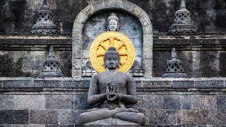 Buddha an einem indonesischen Kloster. Um Buddhist zu werden, bekannt man sich zu Buddha, zum Dharma und zum Sangha.