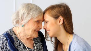 Eine Seniorin und eine junge Frau Stirn an Stirn: Alte Menschen riechen anders als junge, denn im Alter verändert sich die Haut. Die Fette, die wir über die Talgdrüsen ausscheiden, verändern sich. Die Haut verliert an Feuchtigkeit und ist daher im Alter trockener. Damit ändert sich auch die Zusammensetzung der Düfte, die unser Körper und unsere Duftzellen abgeben.