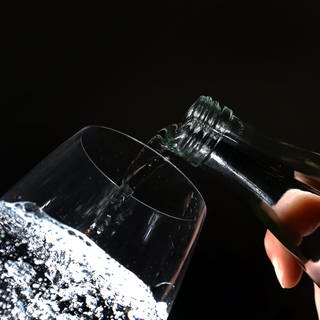 In einem Glas Mineralwasser sprudelt Kohlensäure: Wenn der Druck aus der Flasche genommen wird, das passiert beim Öffnen,  kann das Wasser die Kohlensäure nicht mehr binden. Aus der Kohlensäure entsteht das gasförmige CO2 – und steigt in Form von Bläschen nach oben. So entsteht der Sprudel.