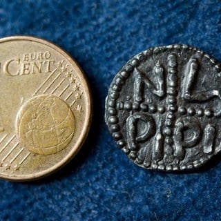 Der wohl älteste deutsche Pfennig, der Denar von Pippin III. (714-768), neben einer modernen Cent-Münze