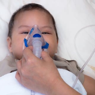 Baby mit RSV hängt an Sauerstoffmaske.
