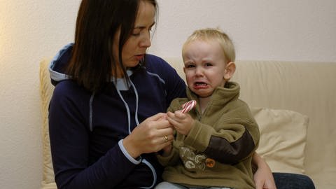 Mutter mit schreiendem Kind. Auch bei sehr kleinen Kindern zwischen null und zwei Jahren gibt es krisenbedingt Auffälligkeiten.