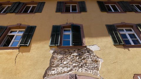 Ein Loch klafft dort, wo an der Wand eines Hauses in der Altstadt von Staufen eigentlich Putz sein sollte.
