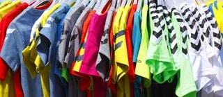  Bunte T-Shirts auf Kleiderbügeln hängend