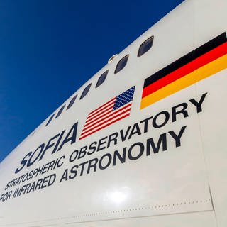 Aufschrift "SOFIA - Stratospheric Observatory for Infrared Astronomy" mit US-amerikanischer und deutscher Flagge auf der Boing 747, in der sich das Teleskop befindet.