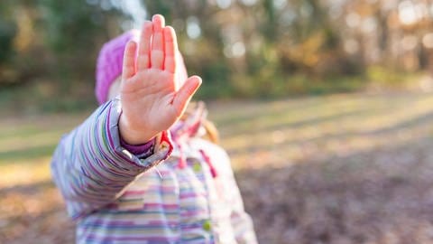 Junges Mädchen streckt ihre Hand als Stopp-Signal vor sich aus. (Foto: IMAGO, IMAGO / Panthermedia)