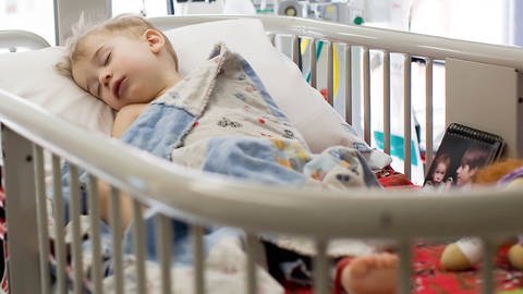 Ein Kleinkind schläft im Krankenhausbett.
