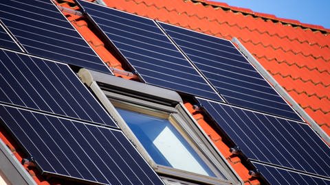 Das Bild zeigt Solarzellen, die auf einem Hausdach installiert sind.