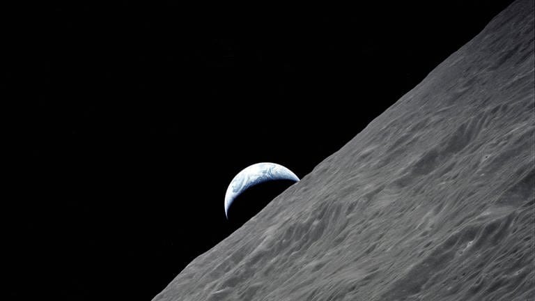 7.-19. Dez. 1972: Die sichelförmige Erde erhebt sich auf diesem spektakulären Foto, das während der letzten Mondlandemission im Apollo-Programm von der Raumsonde Apollo 17 in der Mondumlaufbahn aufgenommen wurde, über den Mondhorizont. 