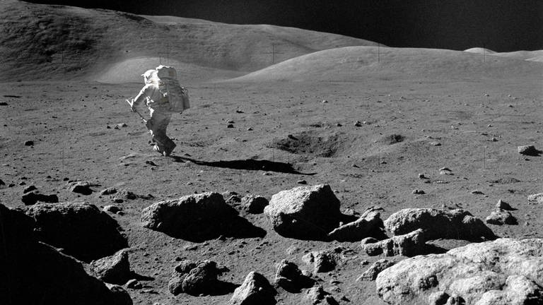 12. Dez. 1972: Der Wissenschafts-Astronaut Harrison H. Schmitt, Pilot der Mondlandefähre, macht sich mit seiner verstellbaren Probenahmeschaufel auf den Weg zu einem ausgewählten Felsen auf der Mondoberfläche, um die Probe für die Untersuchung zu entnehmen.