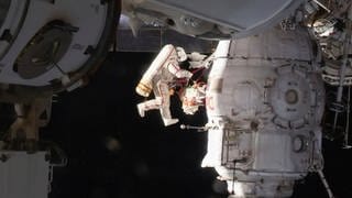 Der russische Kosmonaut Oleg Kononenko untersucht bei einem Außeneinsatz einen Teil des angedockten Raumschiffs Sojus MS-09. 