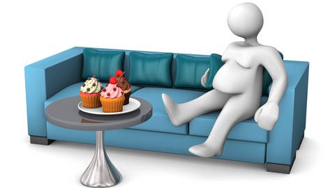 Person sitzt auf dem Sofa und hat Kuchen vor sich.