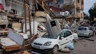 Das Bild zeigt die Folgen des Erdbebens in der Grenzregion TürkeiSyrien: Zerstörte Gebäude, Autos und Straßen.