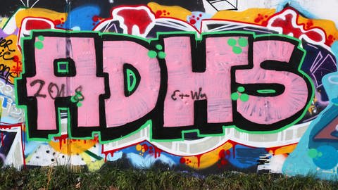 Ein Grafitti bildet die Buchstaben ADHS.