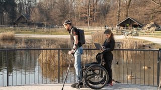 Der ehemalig gelähmte Patient Gert-Jan Oskam steht aus Rollstuhl auf und läuft dank des Gehirn-Rückenmark-Implantats mithilfe von Krücken.