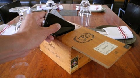 Gast in Restaurant legt sein Handy weg, um während des Essens auf sein Handy zu verzichten.