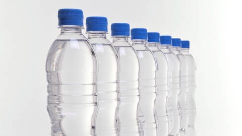 Acht aufgereihte Wasserflaschen aus Plastik.