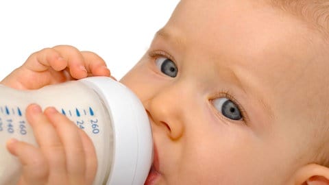 Baby trinkt Milch aus einer Flasche