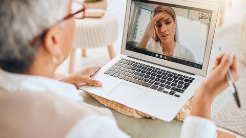 Eine Therapeuten spricht mit einer Patienten auf dem Laptop-Bildschirm