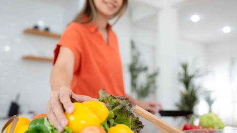 Eine Frau greift zu Gemüse