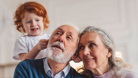 Das Bild zeigt einen Enkel, der mit seinen Großeltern spielt. Symbolbild.