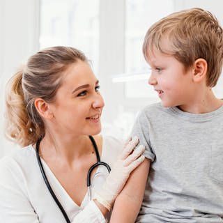 Das Bild zeigt eine Ärztin mit einem kleinen Jungen. Symbolbild.