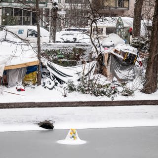 Obdachlose zelten in Berlin im Winter im Schnee.