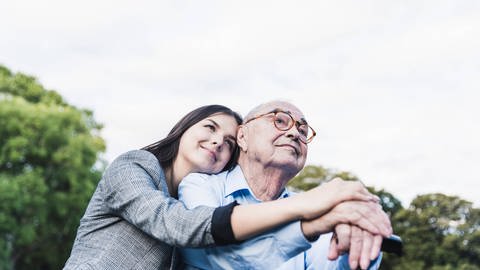 Für eine Ansteckungsgefahr durch den alltäglichen Umgang mit Alzheimer-Patienten gibt es keine Hinweise. Aber möglicherweise haben sich Menschen vor Jahrzehnten über verunreinigte Spritzen infiziert. Junge Frau umarmt alten Mann.