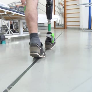 Ein Freiwilliger testet die Prothese mit Gefühl beim Gehen auf einer geraden Linie