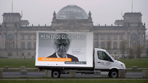 Vor dem Bundestag ein Plakat der Initiative "Für Das Recht auf Letzte Hilfe e.V." unter dem Motto "Mein Ende gehört mir" mit einem Foto von Prof. Dieter Birnbacher, Philosoph mit Schwerpunkt Ethik 