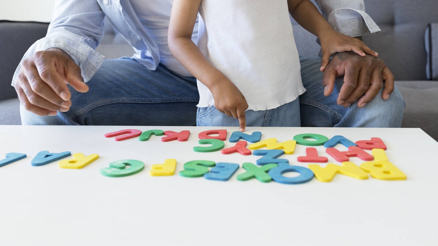 Vater und Tochter bei einem Buchstabenspiel