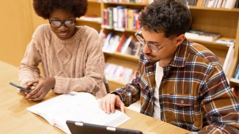 Studierende werden mit den Bafög-Neuerungen besser gefördert, wenn nach der Regelstudienzeit noch Klausuren ausstehen | Studierende lernen gemeinsam in Bibliothek