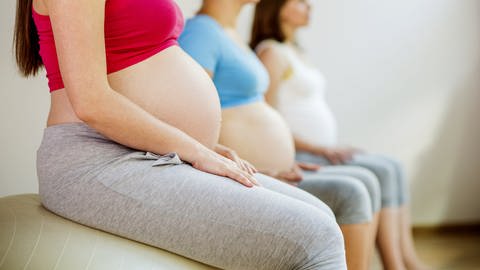 Schwangere Frauen sitzen auf Fitness-Bällen