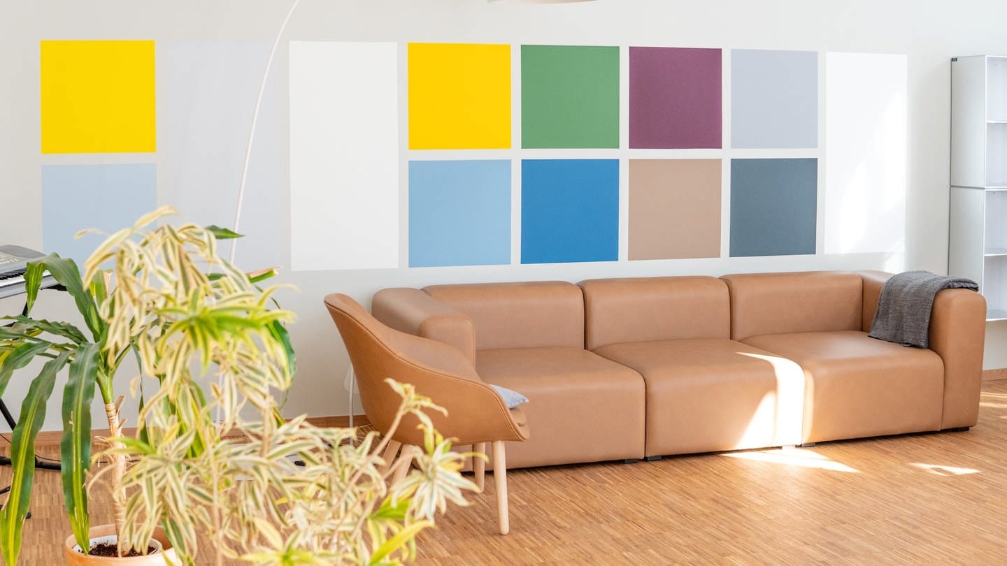Die Architektur in der Psychiatrie kann Patienten beim Gesundwerden helfen: Sofa vor bunter Wand in der 